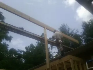 Carpenter setting a ridge beam over a new addition frame — Ice Dam Removal by Roofing Brothers in North Wilkesboro