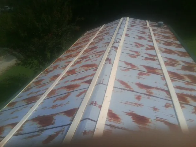 Rusted metal roof panels with new wood purlins before replacement — Storm Damage Roof Repair in North Wilkesboro by Roofing Brothers