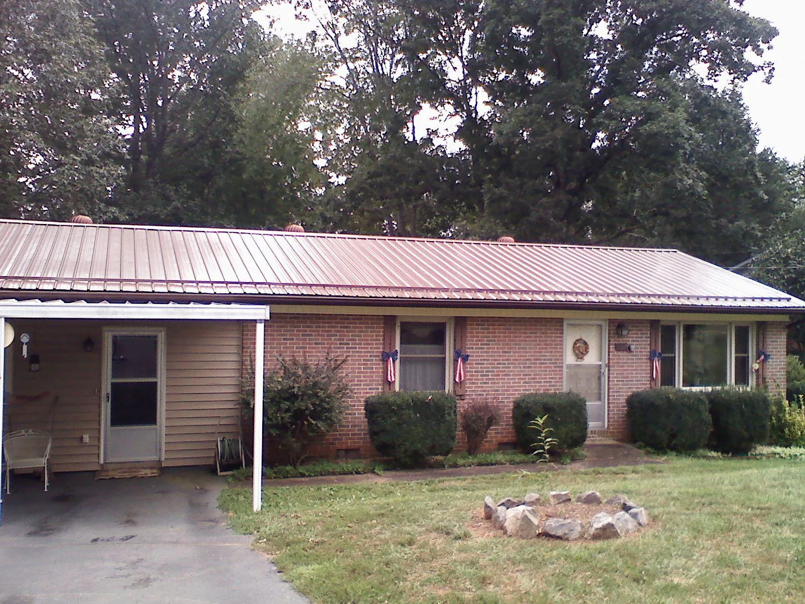 Bronze metal roof and carport on a brick ranch home — Roof Repair work by our crew in North Wilkesboro
